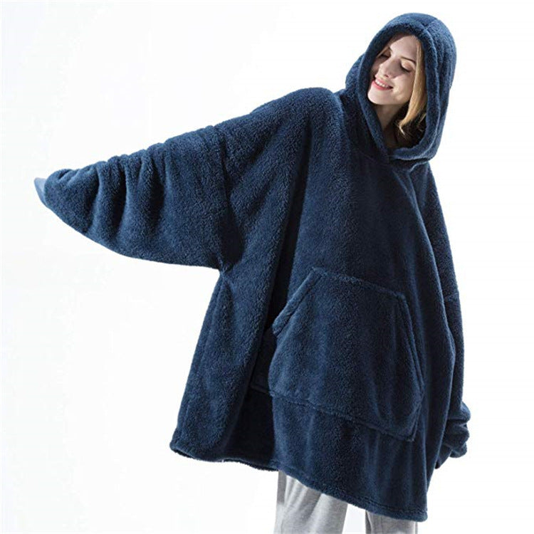 Real product photo of the navy blue Hibernation Hoodie worn with arms outstretched showing the full oversized width