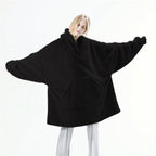 Real product photo of the black Hibernation Hoodie worn with arms outstretched showing the full oversized width