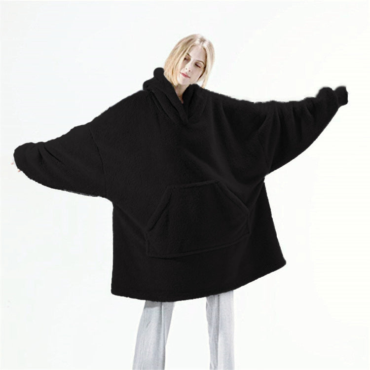 Real product photo of the black Hibernation Hoodie worn with arms outstretched showing the full oversized width
