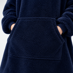 Hands tucked into the oversized kangaroo pocket of the navy Hibernation Hoodie