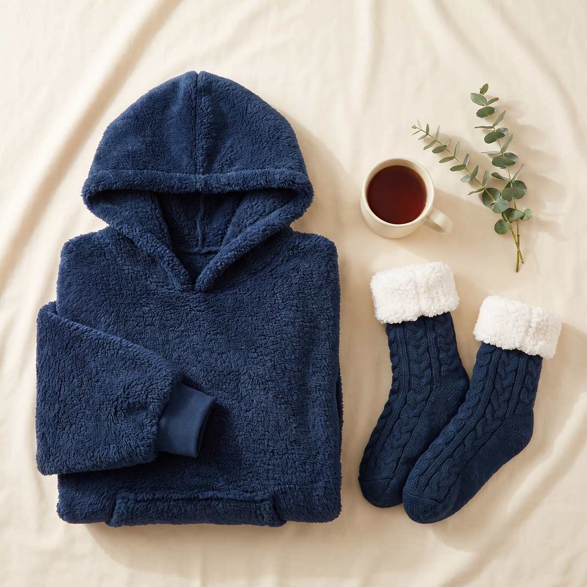 Navy Hibernation Hoodie folded beside matching navy cable knit slipper socks